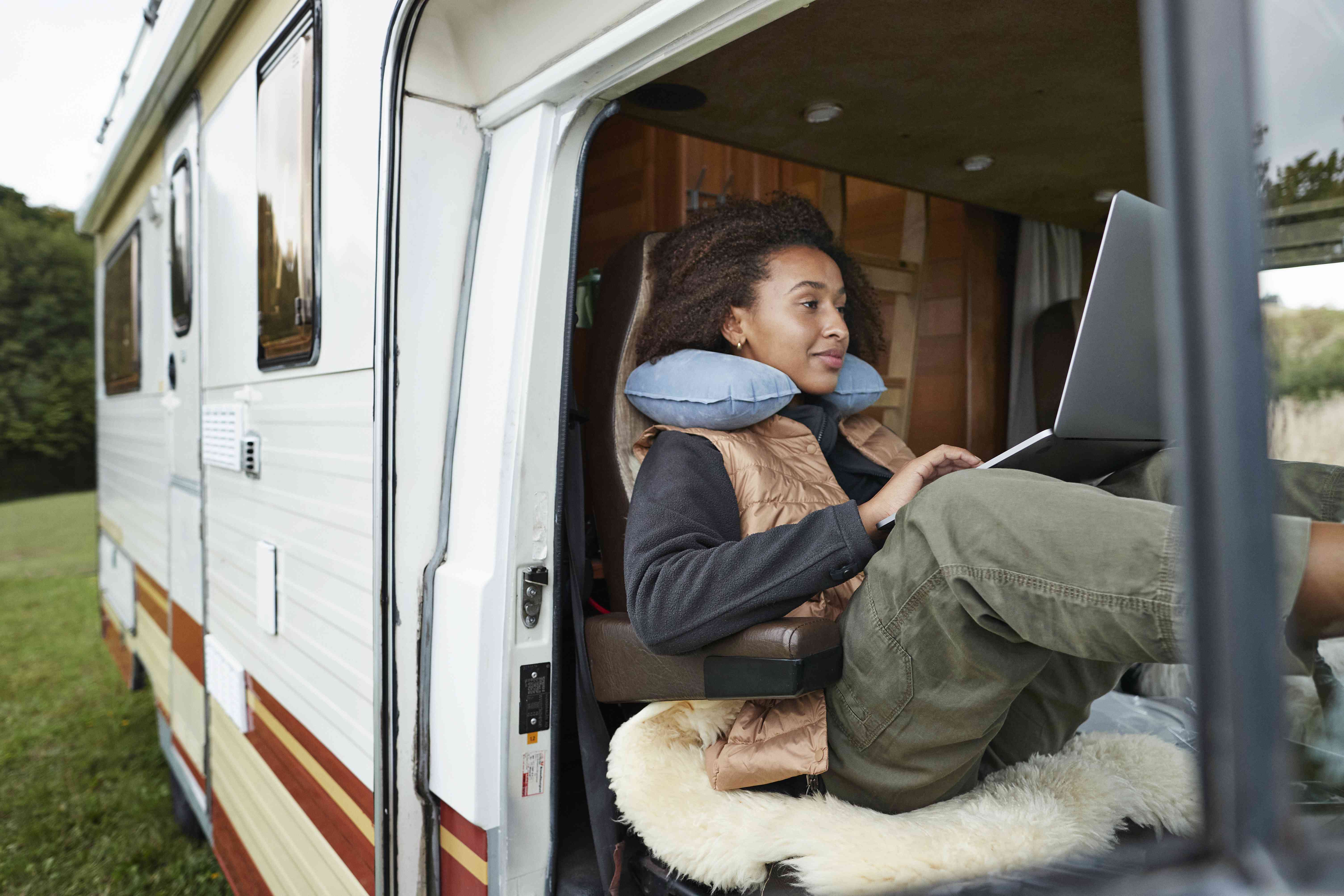 A woman uses a laptop in a motorhome.