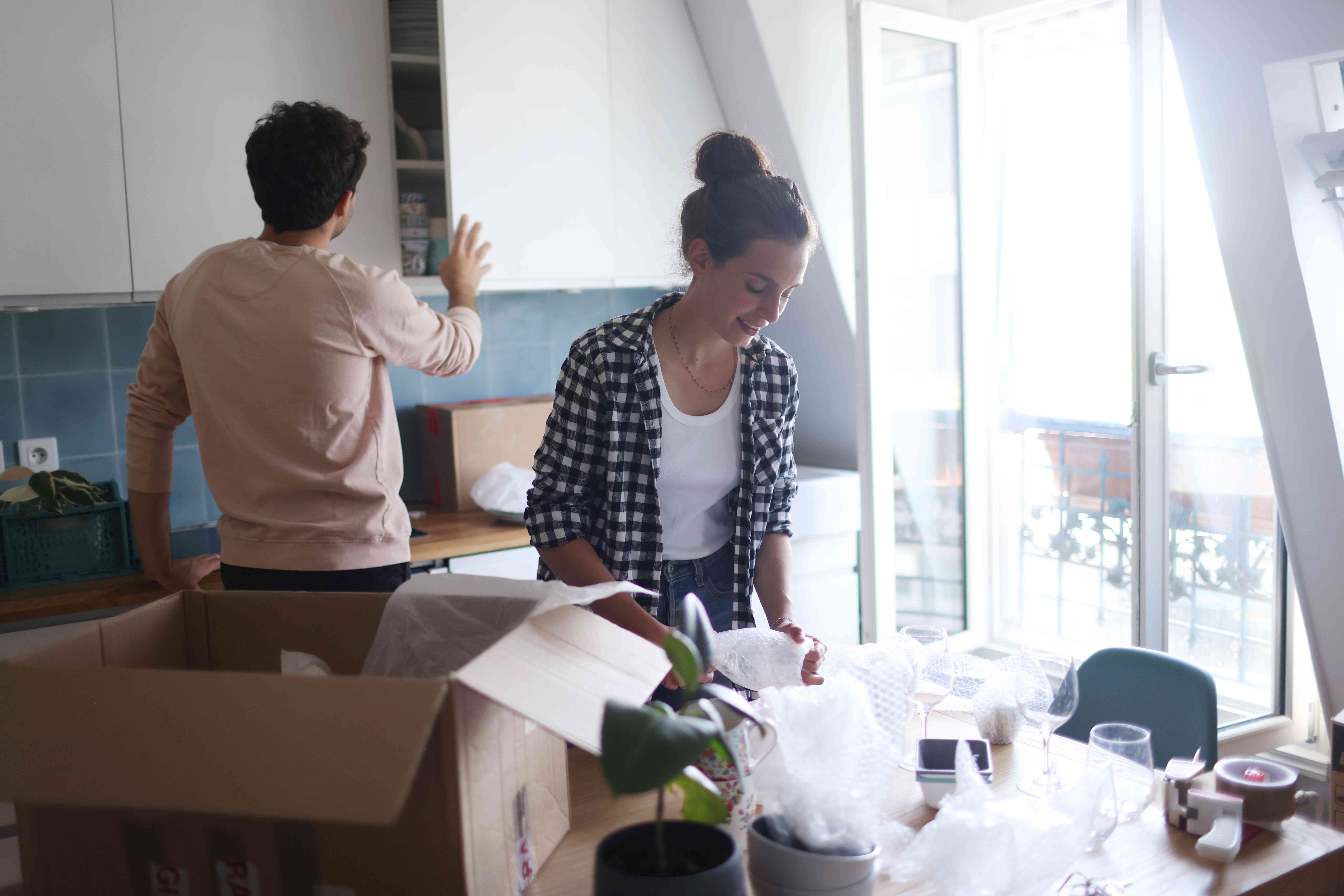 A couple unpacking boxes in a kitchen
