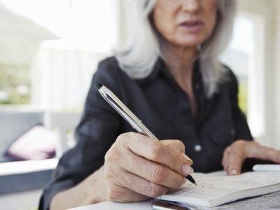 Mature Woman Writing in Cheque Book