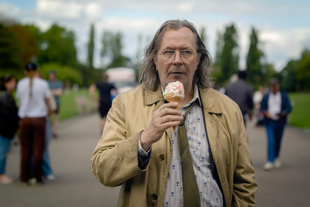 Gary Oldman plays Jackson Lambe in 'Slow Horses,' shown here walking through a park with an ice cream cone