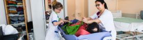 Aide soignantes posant un harnais lors du transfert d’un malade