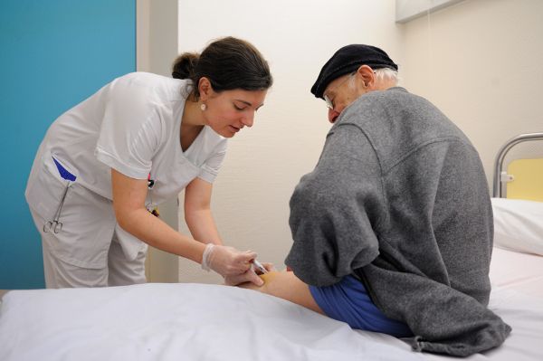 Infirmière effectuant une injection sous cutanée sur un résident d’un EHPAD