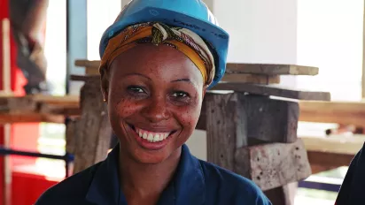 A woman with a hard hat smiling.