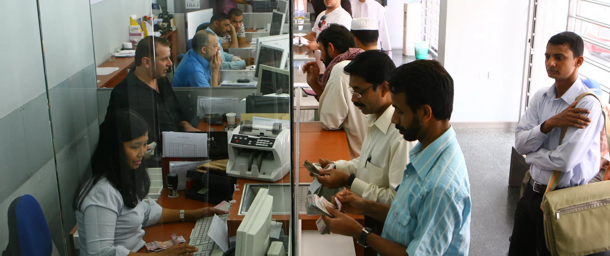 Workers at a local currency exchange and money transfer office provide service to customers.