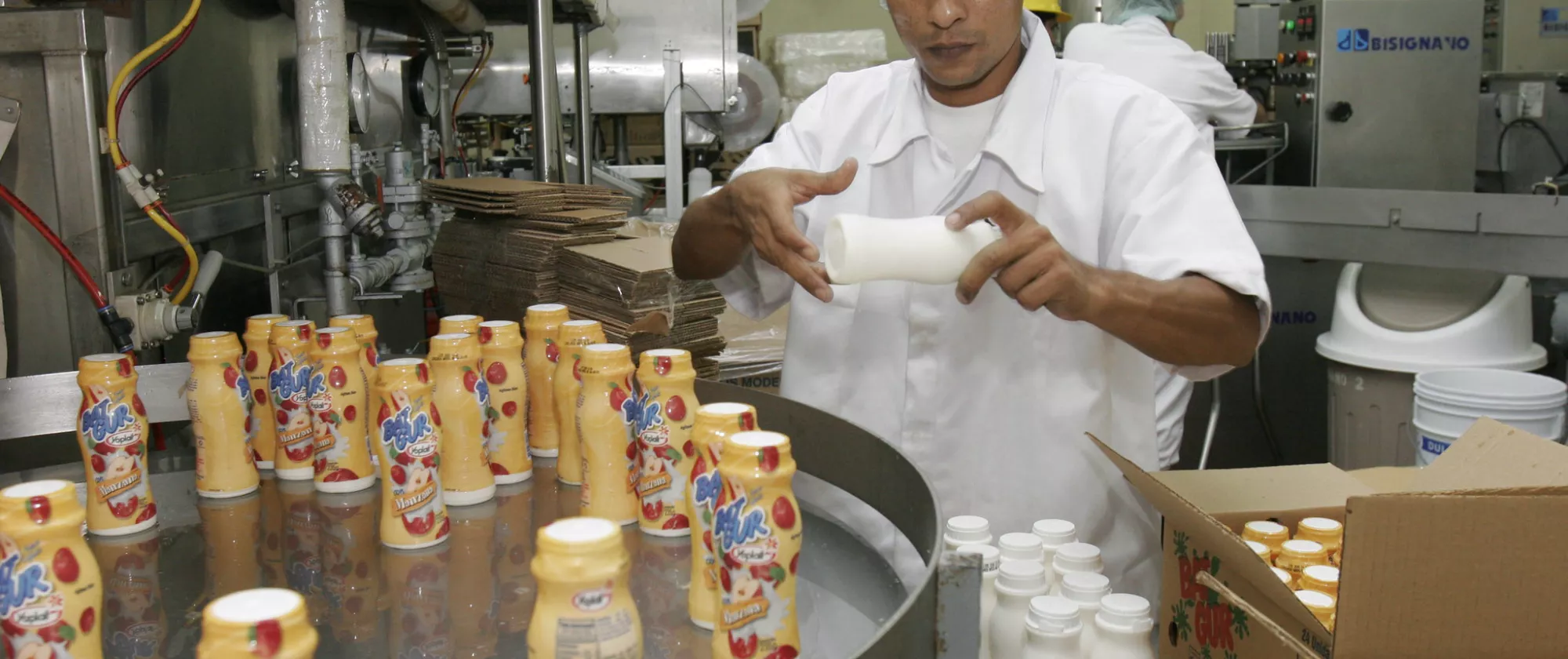 Worker packaging yogurt bottles.