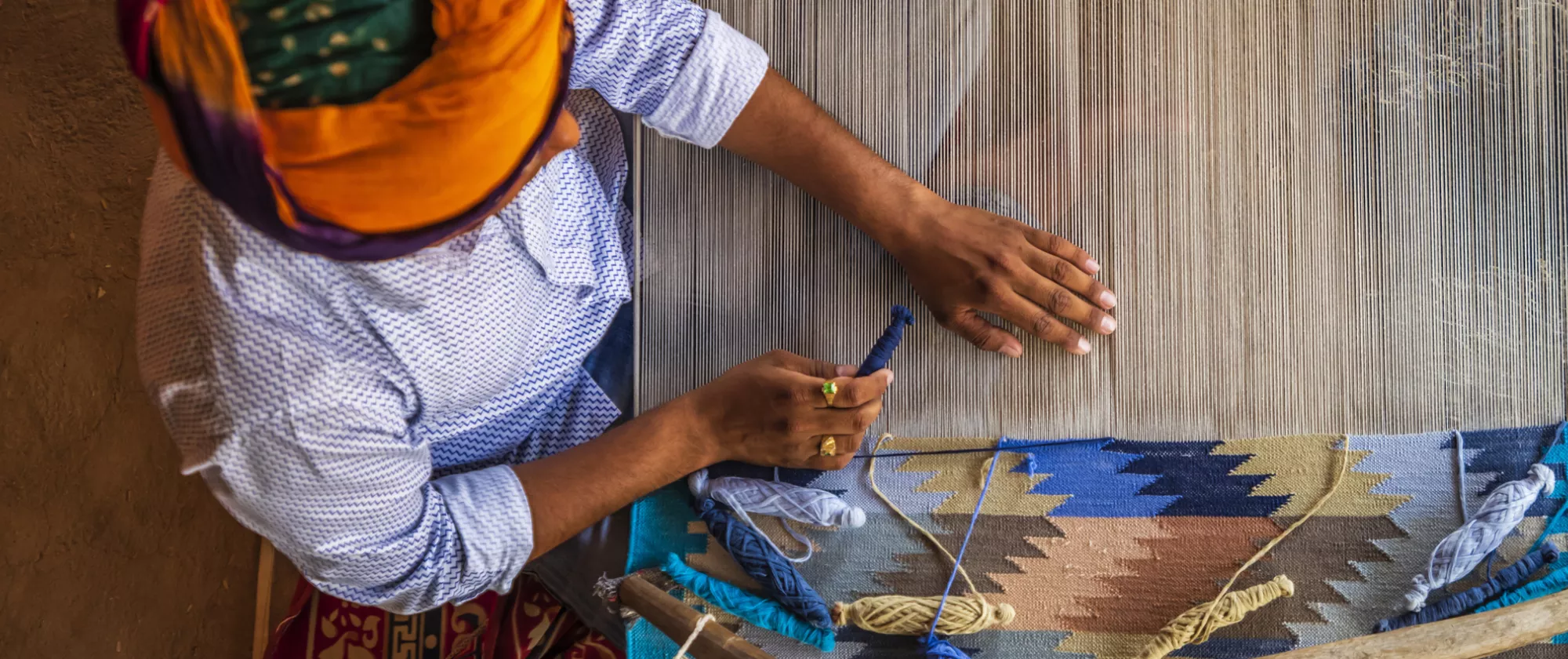 Indian man weaving durries