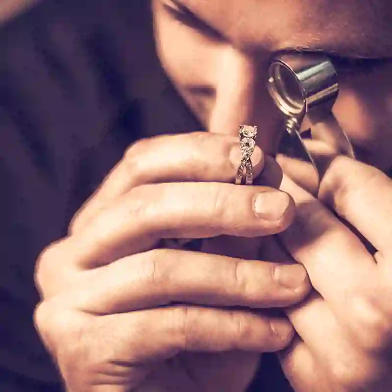A jeweler uses a loupe to inspect a ring