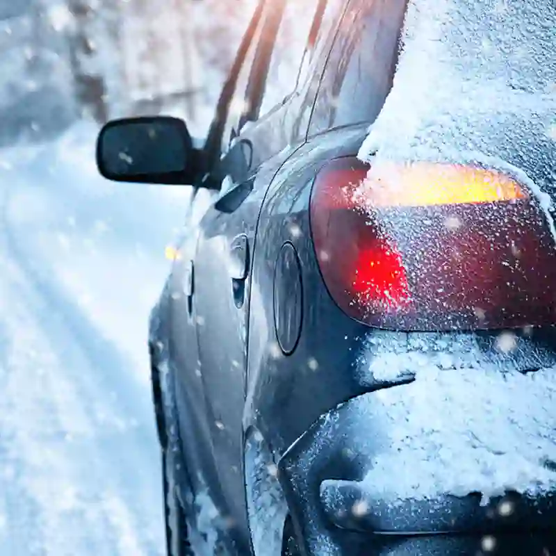 A car ventures down a dangerous snowy road