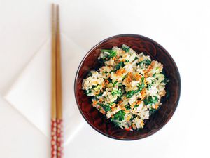 A bowl of fried rice with bok choy, kale, and crisp fried garlic.