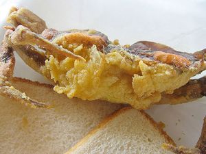 Fried soft shell crab with two slices of bread. 