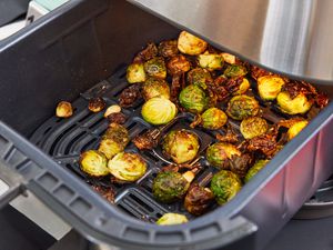 a closeup look at crispy Brussels sprouts in an air fryer basket
