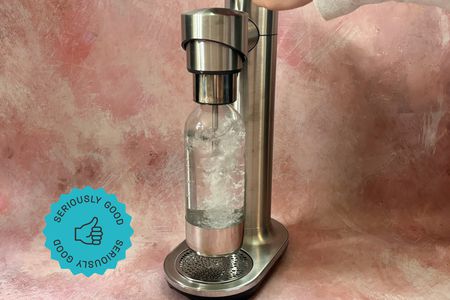 A person carbonating water with the Breville soda maker.
