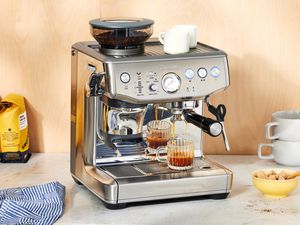 The Breville Barista Express Impress on a white marble countertop