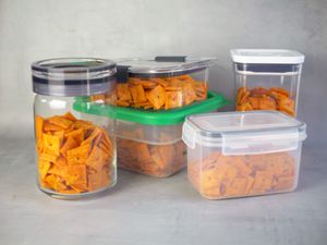 Dry food storage containers filled with Cheez-Its on a gray surface
