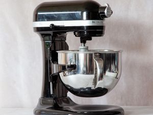 a black kitchenaid stand mixer on a marble surface