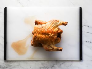 a roast chicken on an oxo cutting board