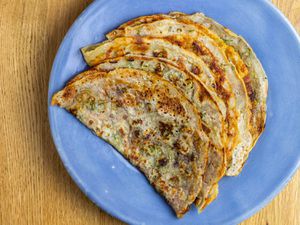 A pile of thin, folded scallion pancakes made with sourdough discard