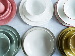 A selection of dinnerware place settings on a grey surface