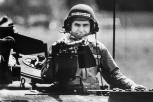 (Original Caption) 9/13/1988 Detroit, MI: Presidential candidate, Mike Dukakis, wearing an army tanker's helmet, peers behind the loader's weapon of an MIAI Abrams Main Battle Tank during a demonstration ride tin the tank at he HQ of General Dynamics Land Systems Division in Detroit, where the tanks are manufactured. BPA2# 1433.