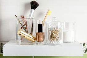 cosmetics in clear containers on a white shelf