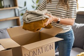 Woman decluttering clothing in donation box