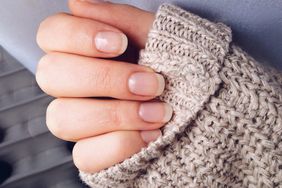 close of woman's hands wearing a sweater