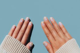 Hands in sweater with glitter nail polish