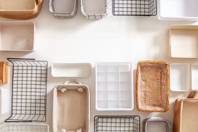 Top view of empty closet organization boxes and steel wire baskets in different shape placed on white marble table with copy space. Marie Kondo hikidashi boxes for tidying clothes and drawer storage