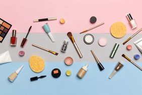 Makeup containers and brushes on a colorful background