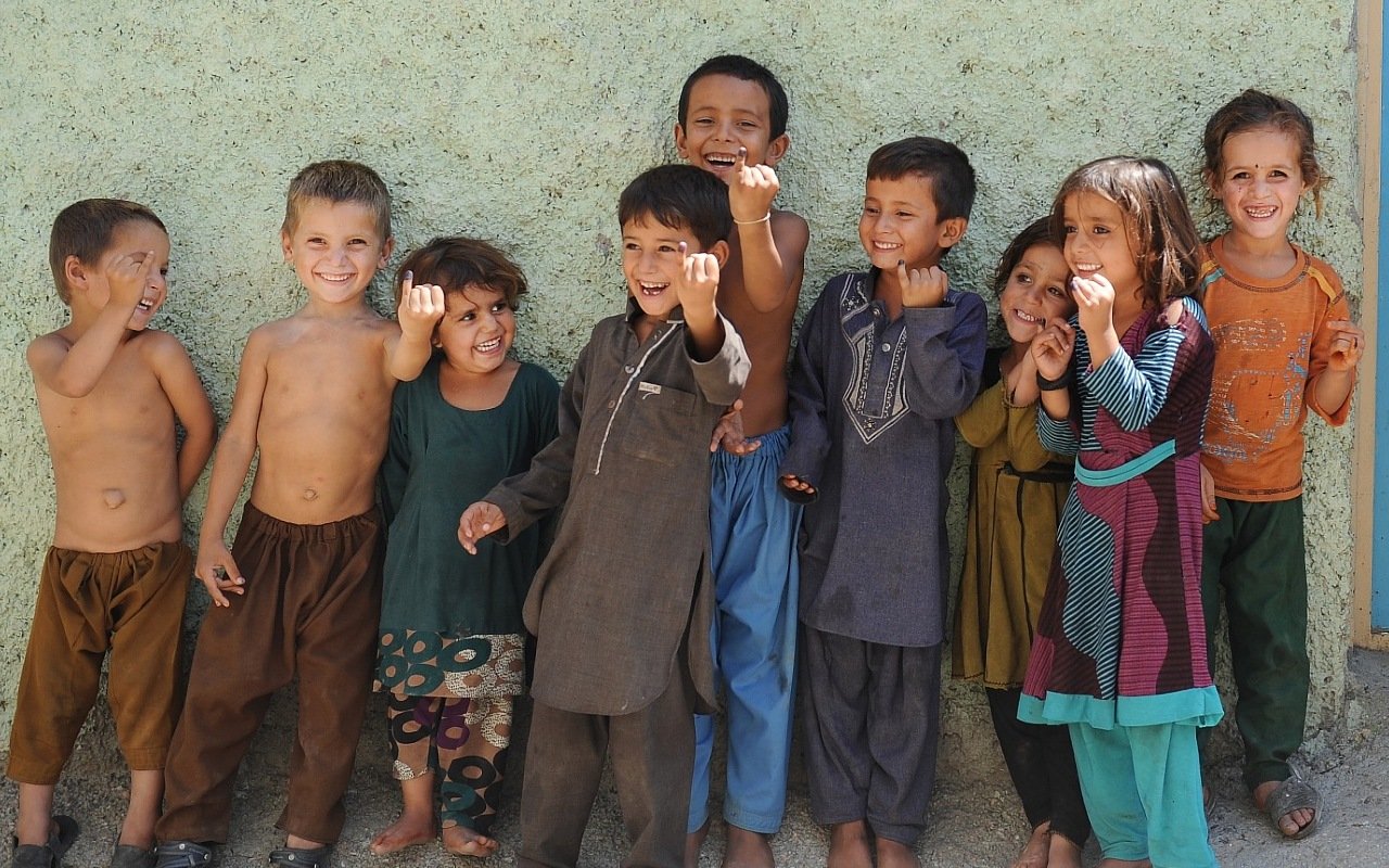 Afghan children show their fingers marked after they all received drops of polio.