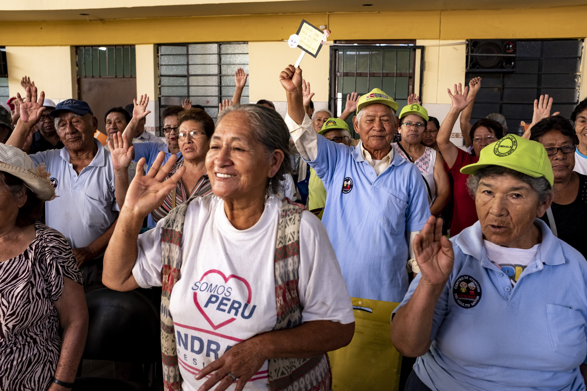 A group of older people raising their hands