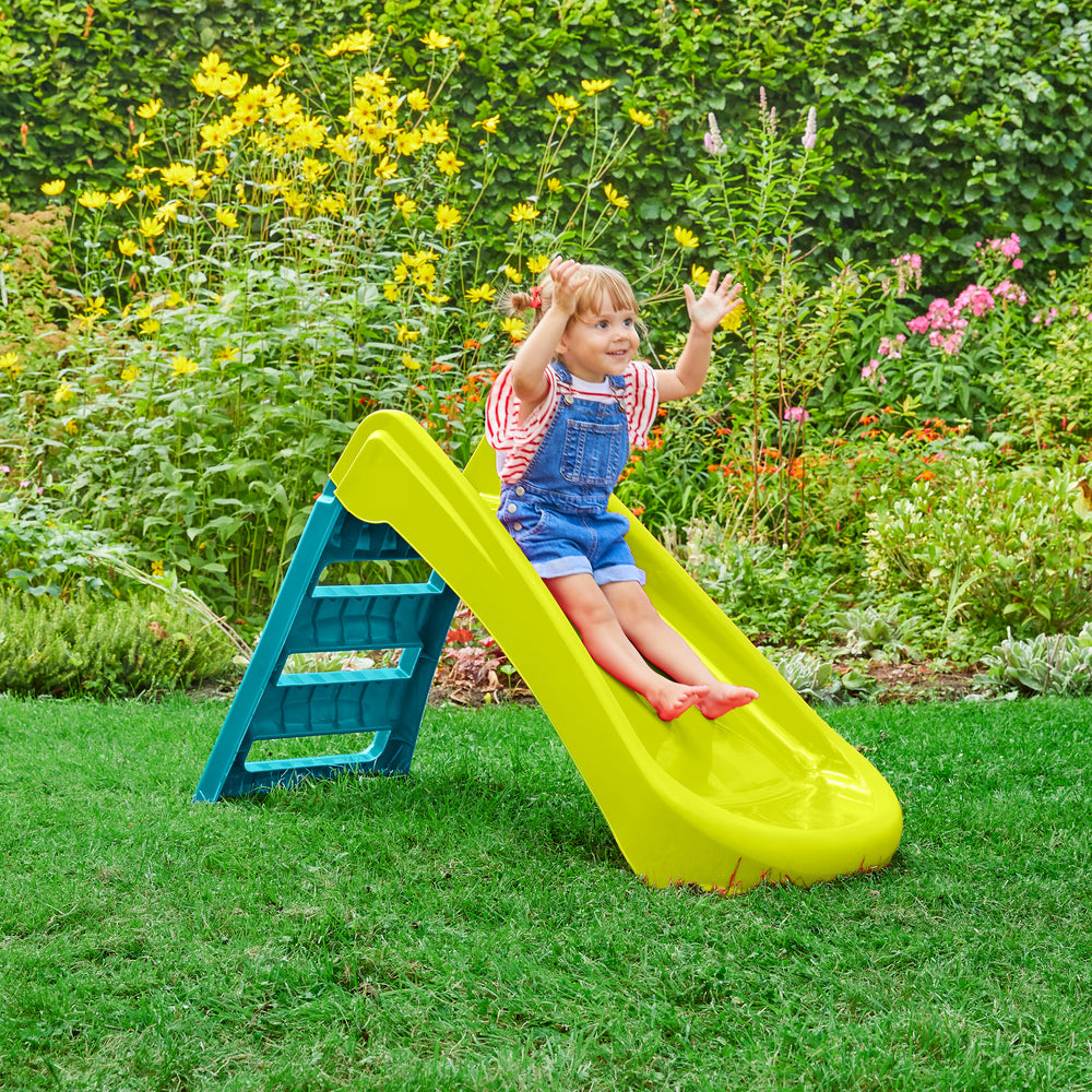 Child playing on a plastic garden slide