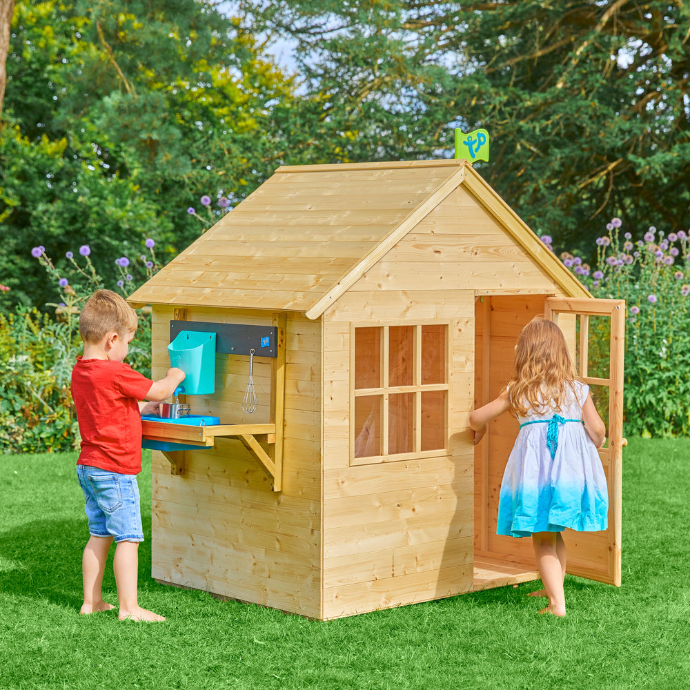 Children playing in a wooden playhouse
