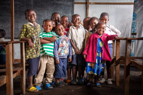 Un groupe d'enfants se tient debout dans une salle de classe temporaire installée par l'UNICEF.