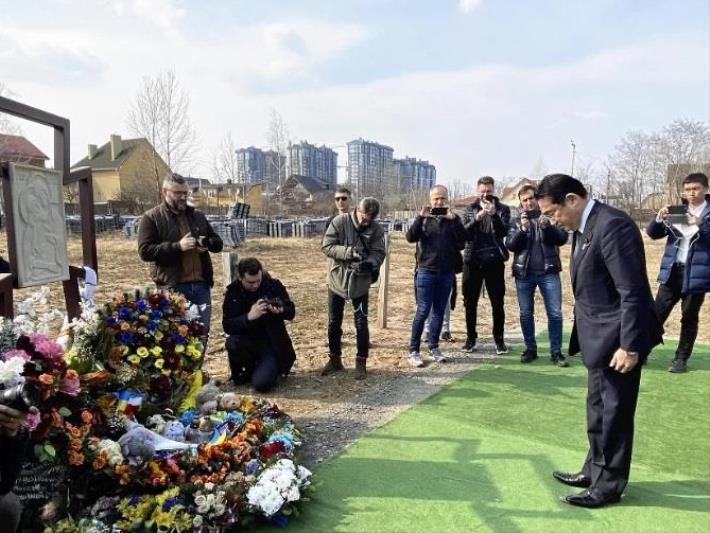 ウクライナ・キーウ近郊ブチャを訪れ、集団埋葬地で献花し、黙とうする岸田首相。首相はこの後、キーウに移動し、ウクライナのゼレンスキー大統領と会談した（２０２３年３月２１日）