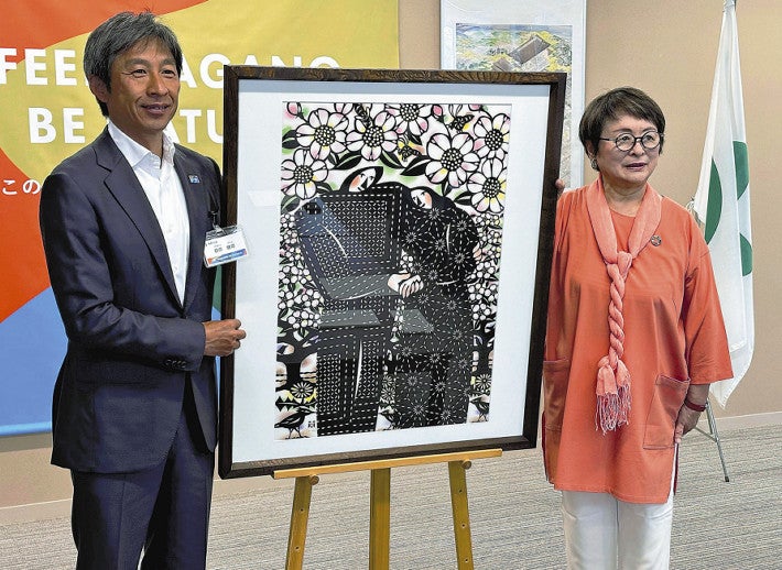 切り絵作家の柳沢さん（右）から珠洲市に贈る作品を託された荻原市長（長野市役所で）
