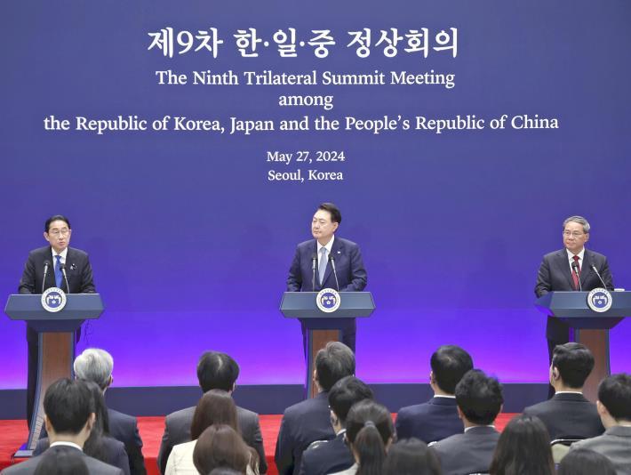 日中韓首脳会談後の共同記者発表で発言する岸田首相（左）。右は中国の李強首相、中央は韓国の尹錫悦大統領（５月２７日午前、ソウルの青瓦台迎賓館で）