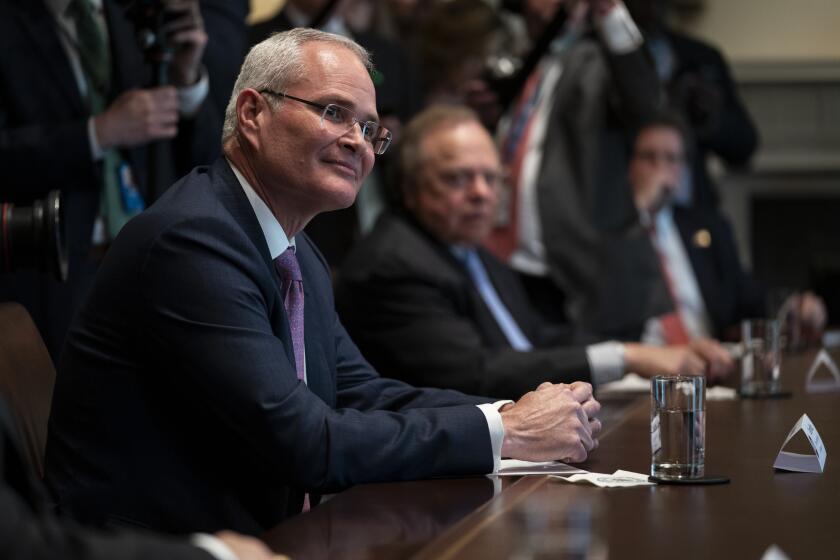 Exxon Mobil CEO Darren Woods listens as President Donald Trump speaks during a meeting with energy sector business leaders in the Cabinet Room of the White House, Friday, April 3, 2020, in Washington. (AP Photo/Evan Vucci)