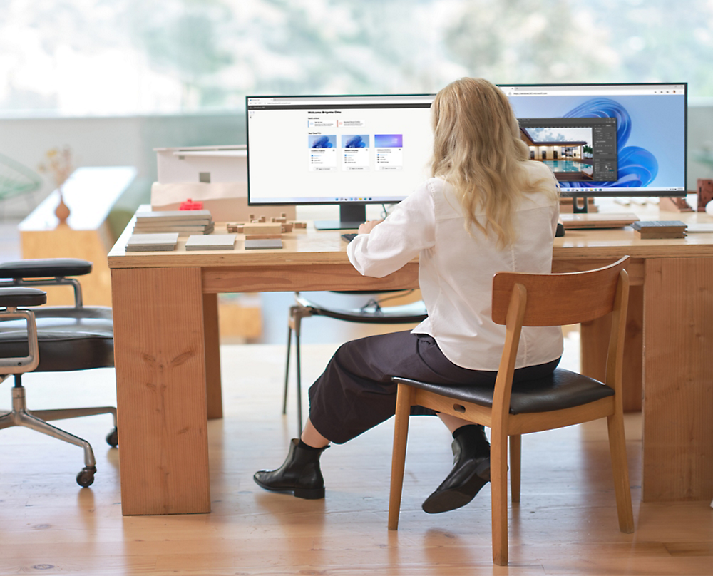 En person sitter vid ett skrivbord och tittar på en dator