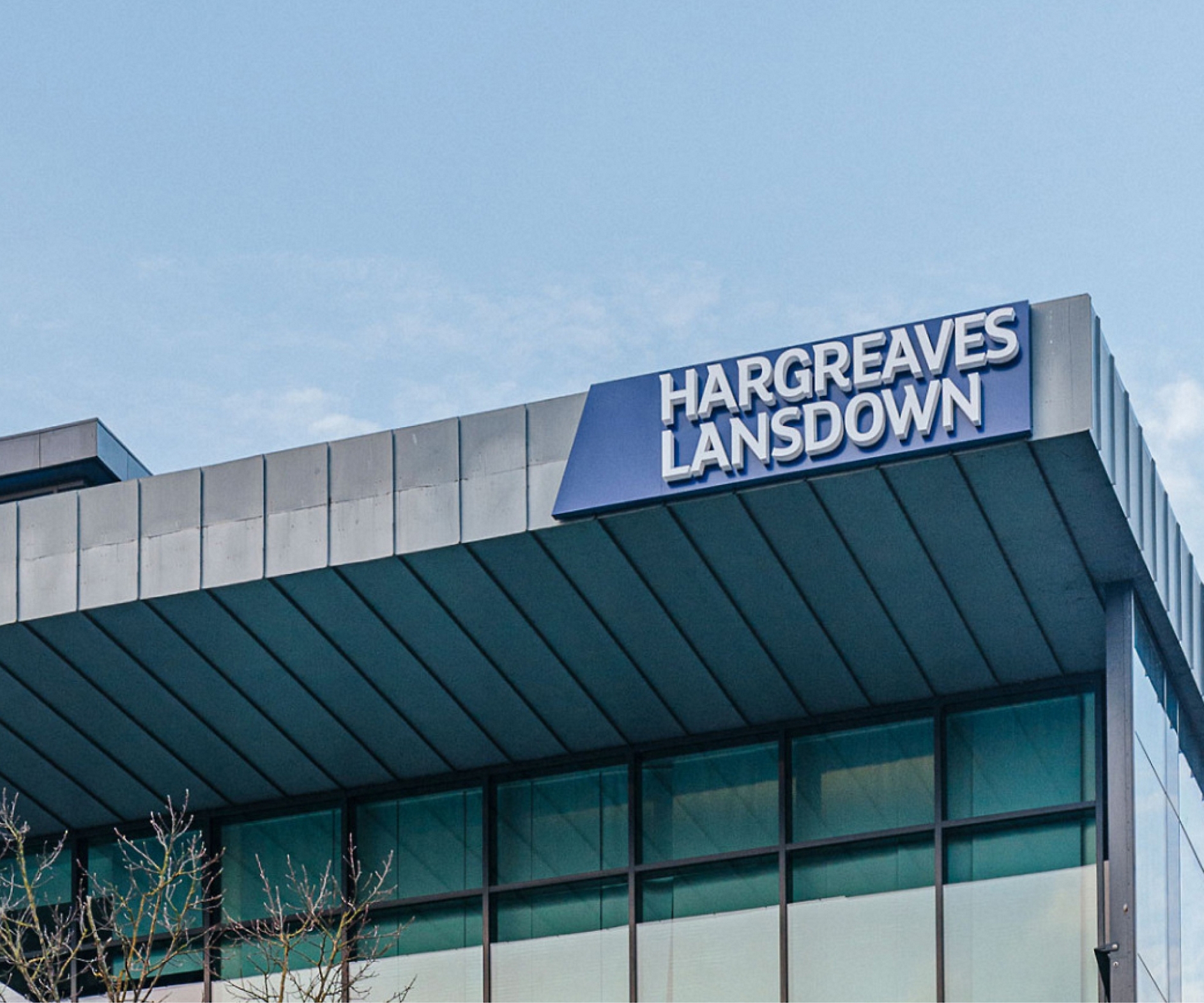 Nápis „hargreaves lansdown“ v horní části moderní budovy s jasnou oblohou v pozadí