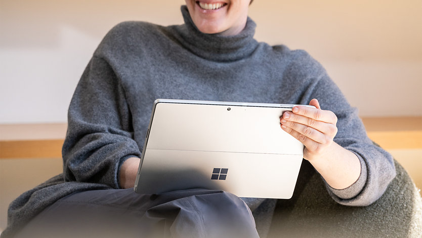 Una persona con un dispositivo Surface per le aziende in mano.