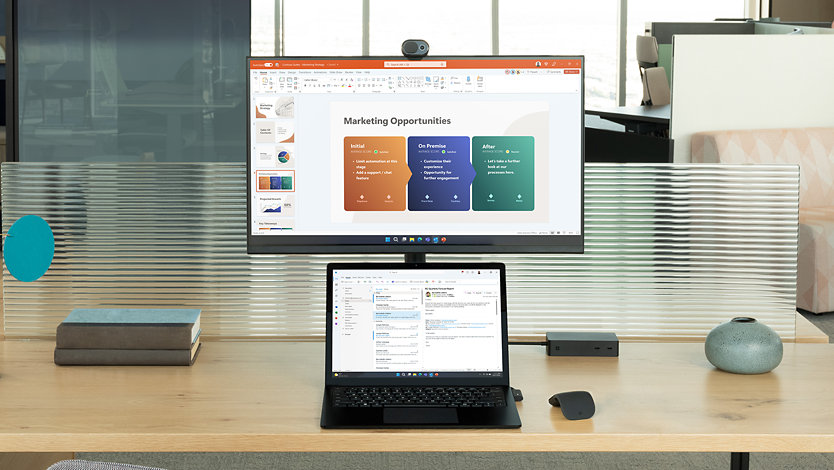 Surface Laptop 5 för företag med Windows 11 på skärmen, på ett skrivbord med en bildskärm. 