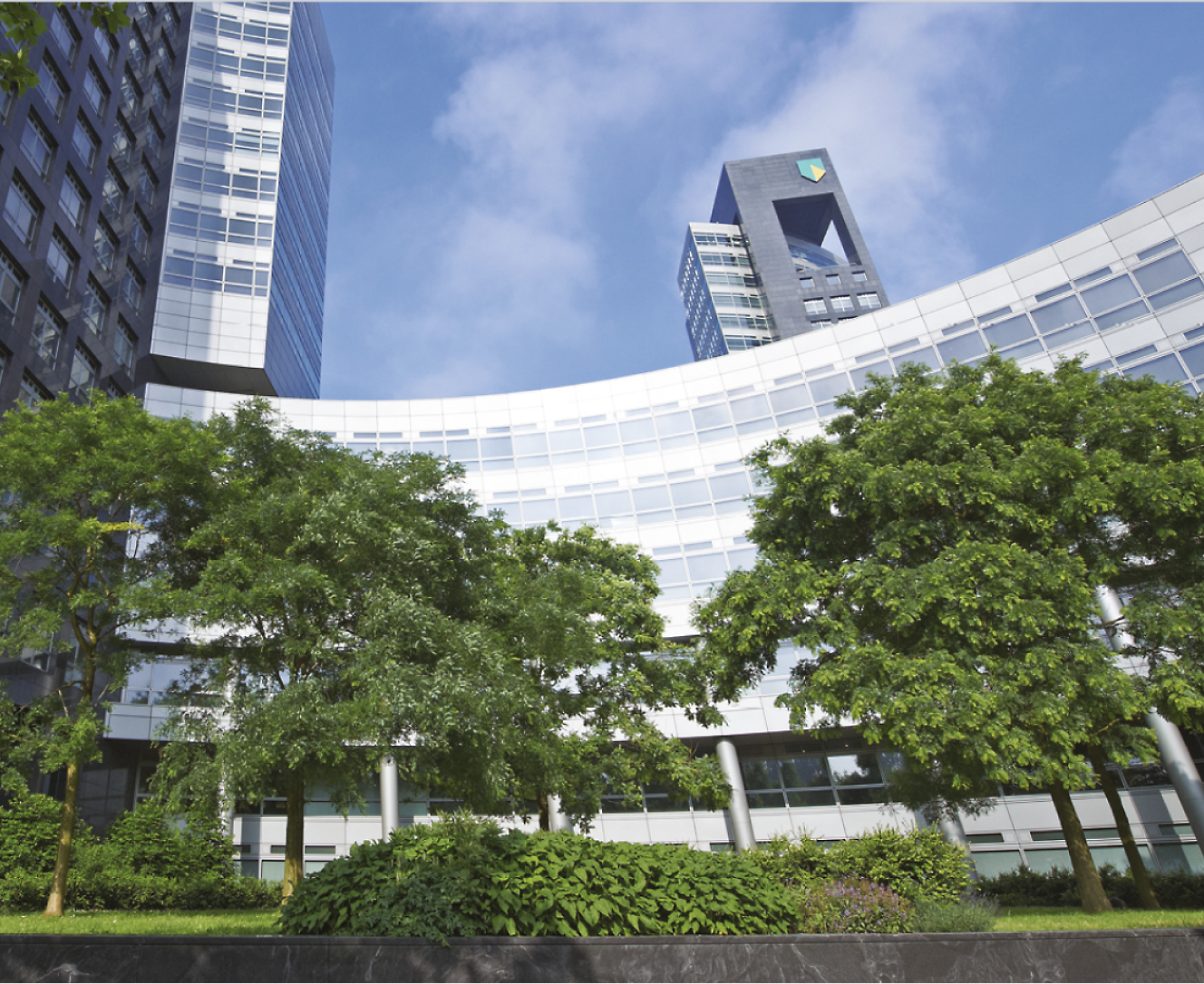 صورة لمبنى إداري مع حديقة أمامية بها أشجار خضراء