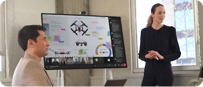 Une femme présente des données sur un Microsoft Surface Hub 2S lors d’une réunion Teams