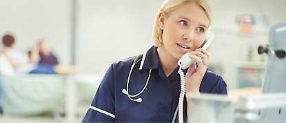 Pielęgniarka rozmawiająca przez telefon w szpitalu.