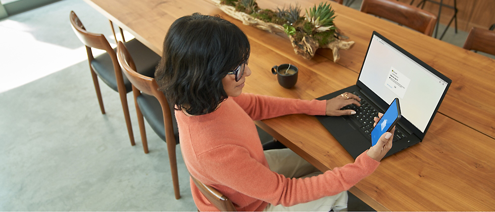En person sitter vid ett bord och använder en dator