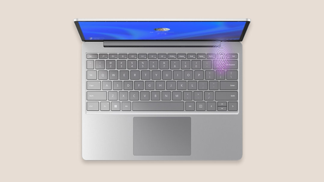 Vista aérea de Surface Laptop Go 3 en platino con el lector de huellas digitales iluminado en la esquina superior derecha del teclado.