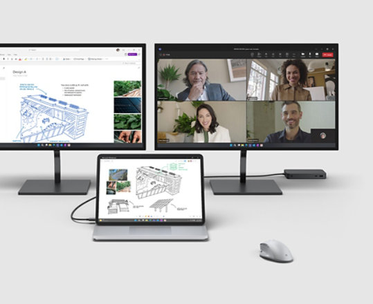 Surface Laptop Studio 2 připojený ke dvěma monitorům s různým příslušenstvím okolo