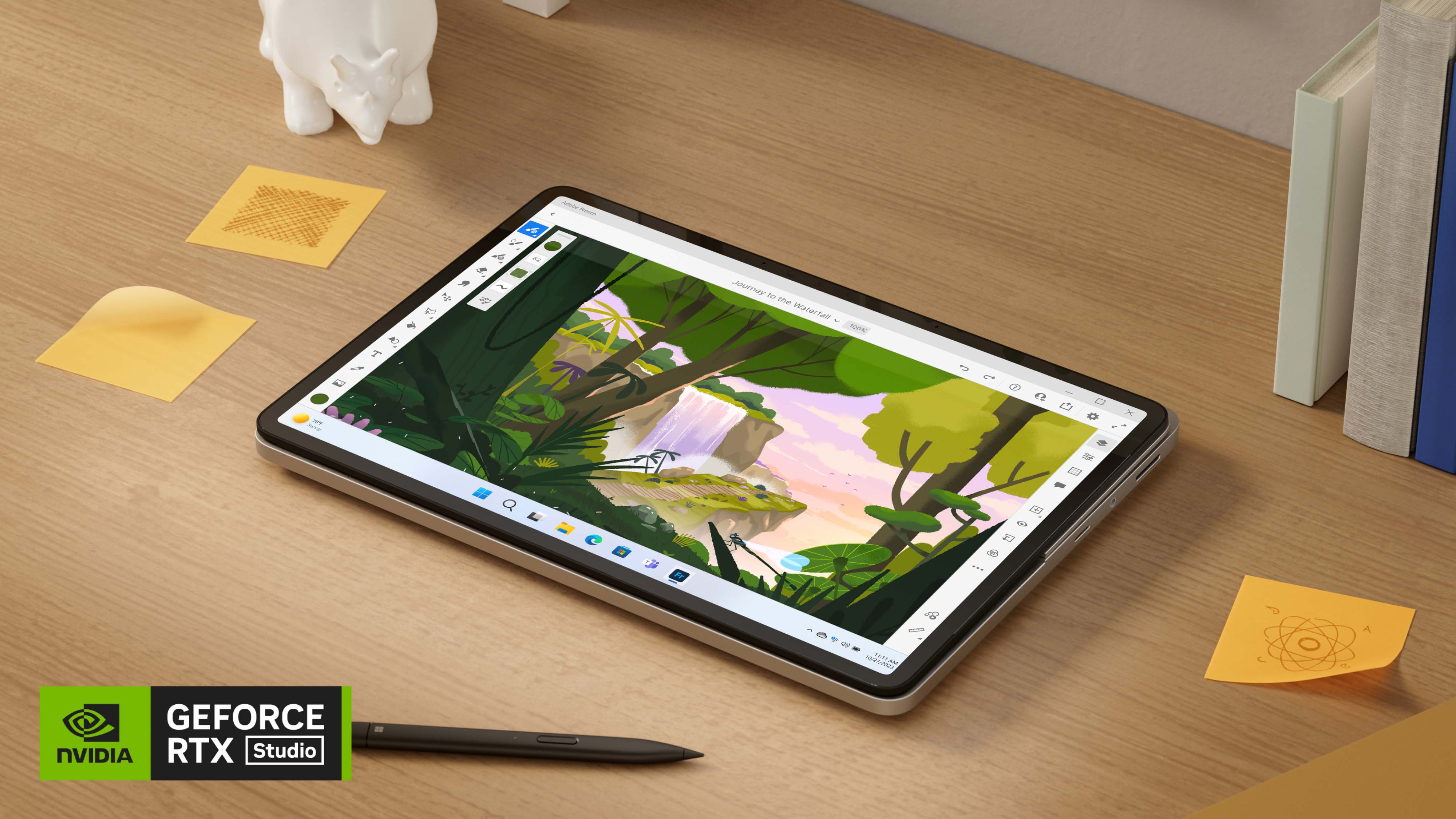 木製の机の上に　Surface スリム ペン 2 と付箋紙の横に置かれた、タブレットモードの Surface Laptop Studio 2。