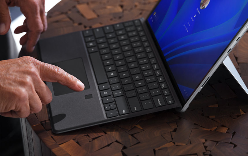 A hand with an extended index finger hovering above Surface Pro Signature Keyboard with Fingerprint Reader.